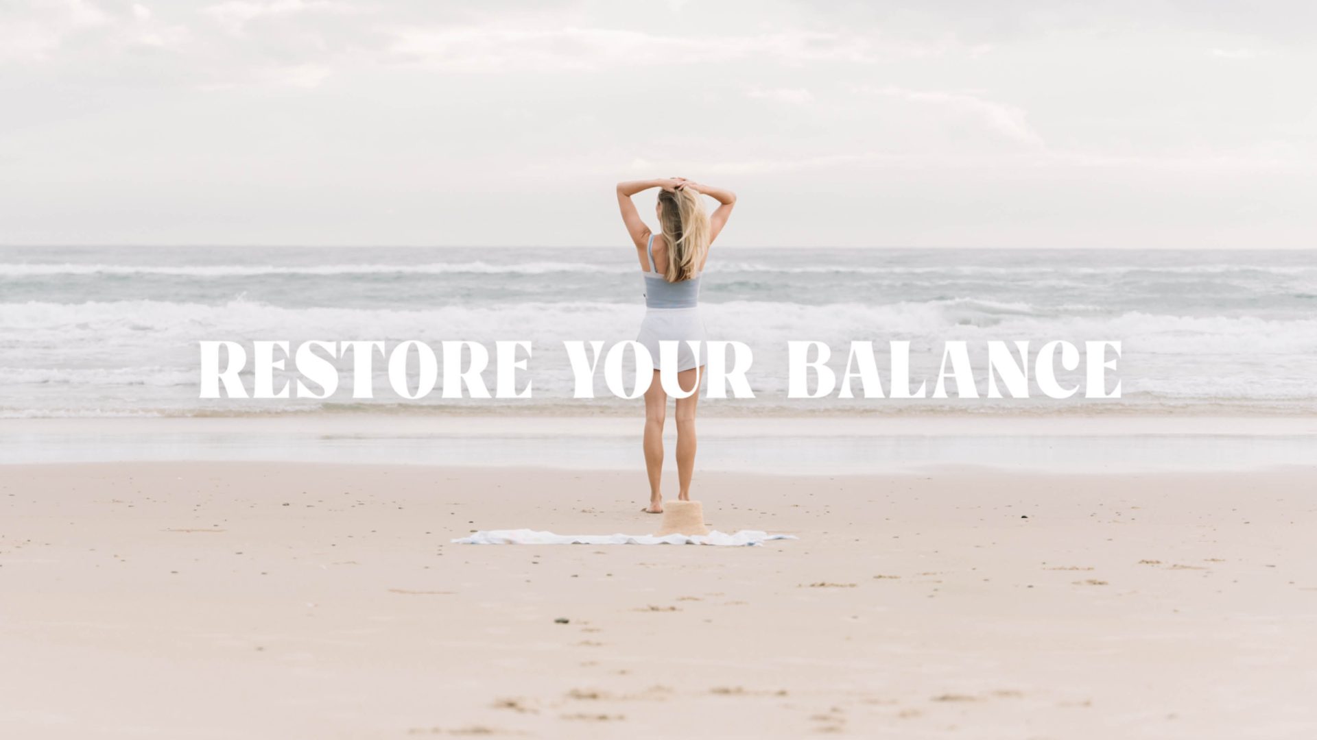Blonde woman named Danielle Bowern stands at the beach in Tweed Heads looking refreshed by Alkalined water. Creative direction and brand design by Votive Brands.