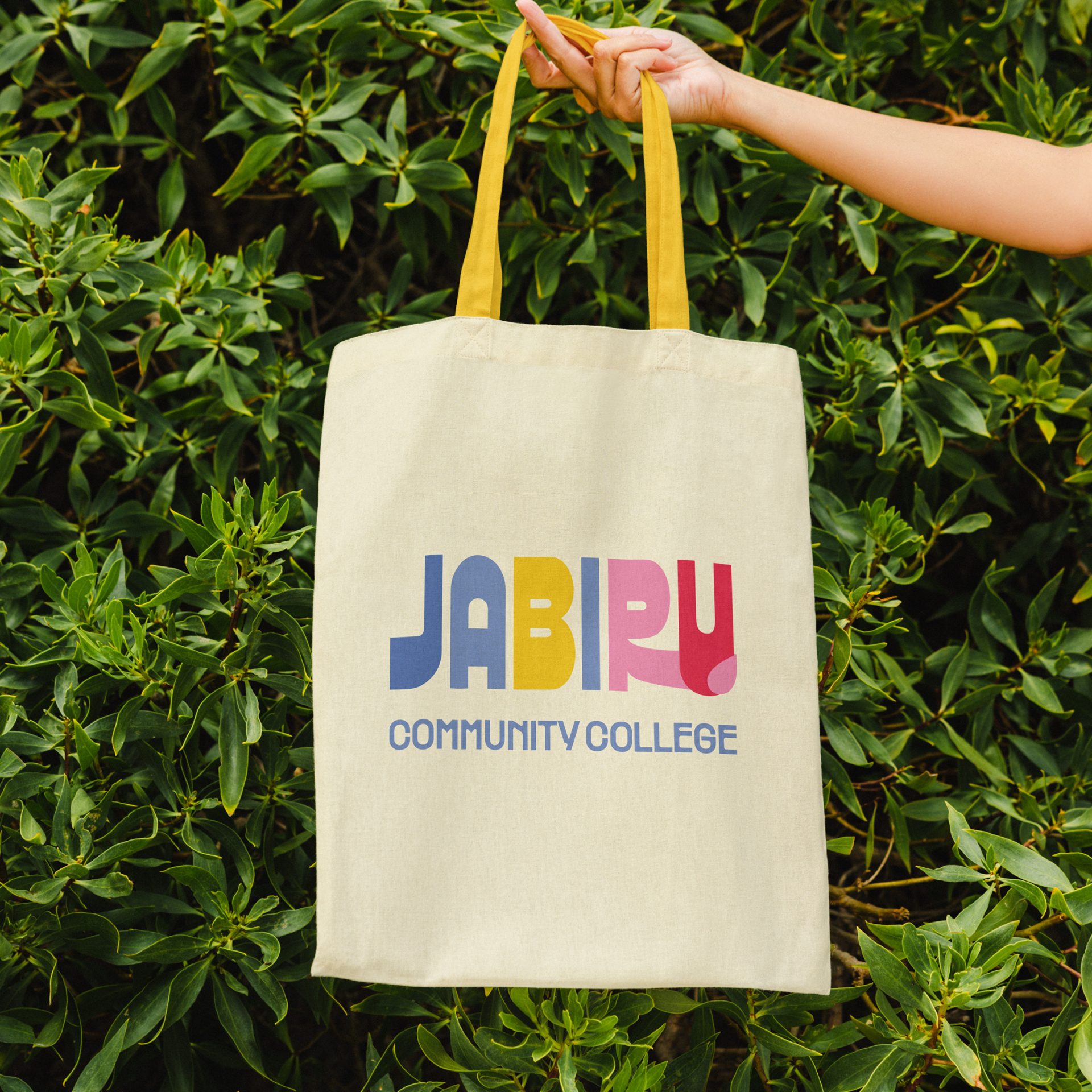 Tote bag showing a custom logo design Jabiru Community College, featuring a bright, bold, clean aesthetic and queer-friendly rainbow tones.